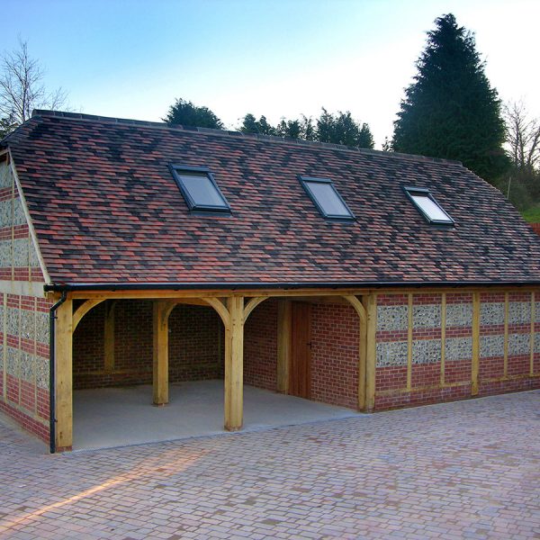 A beautiful flint and brick infill transforms this oak frame (G29-TS) into a building that will span many generations. This hard-wearing finish can sometimes solve Building and Fire Regulation issues when constructing on a boundary line.